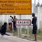 Migrants stand near a city sign along a road near the makeshift camp called "The New Jungle" in Calais, France, August 19, 2015. T REUTERS/Regis Duvignau