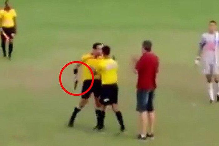 Soccer referee pulls out gun mid match