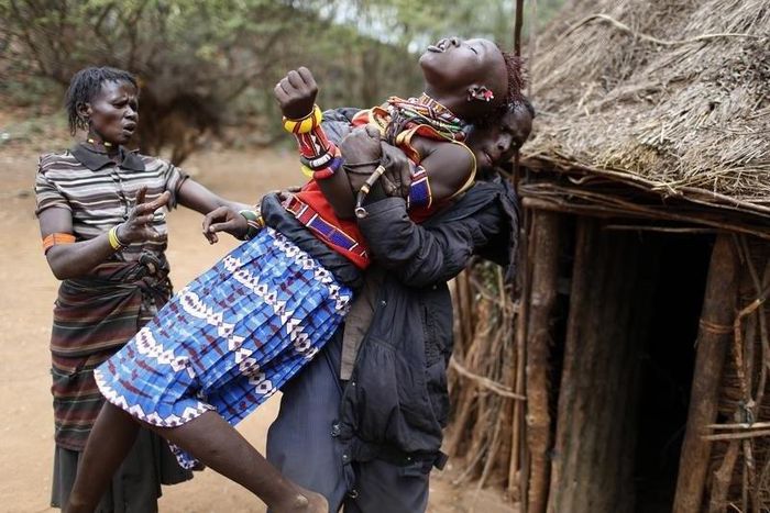 A man holds a girl as she tries to escape when she realised she is to to be married, about 80 km (50 miles) from the town of Marigat in Baringo County December 7, 2014. REUTERS/Siegfried Modola