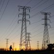 A man walks past electricity pylons as he returns from work in Soweto, outside Johannesburg May 15, 2012. REUTERS/Siphiwe Sibeko