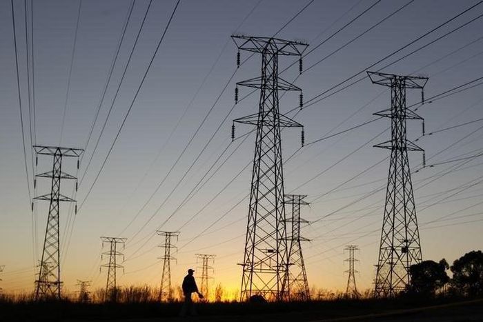 A man walks past electricity pylons as he returns from work in Soweto, outside Johannesburg May 15, 2012. REUTERS/Siphiwe Sibeko
