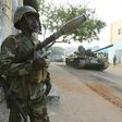 A Somali army soldier keeps guard as a tank rolls past after they captured the town of Barawe during the second phase of Operation Indian Ocean October 6, 2014. REUTERS/Feisal Omar
