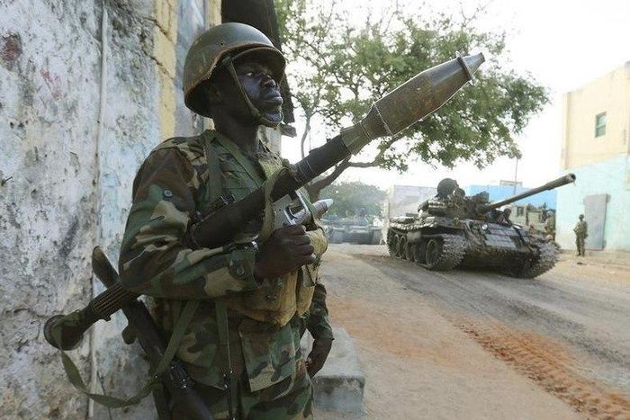 A Somali army soldier keeps guard as a tank rolls past after they captured the town of Barawe during the second phase of Operation Indian Ocean October 6, 2014. REUTERS/Feisal Omar
