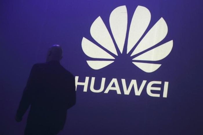 A man walks past a logo during the presentation the Huawei's new smartphone, the Ascend P7, launched by China's Huawei Technologies in Paris, May 7, 2014. REUTERS/Philippe Wojazer/Files