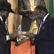 South Sudan's President Salva Kiir (L) and South Sudan's rebel commander Riek Machar exchange documents after signing a ceasefire agreement during the Inter Governmental Authority on Development (IGAD) Summit on the case of South Sudan in Ethiopia's ca...