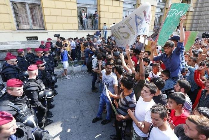Hungarian police officers face migrants outside the Eastern railway station in Budapest, Hungary, September 2, 2015. REUTERS/Laszlo Balogh