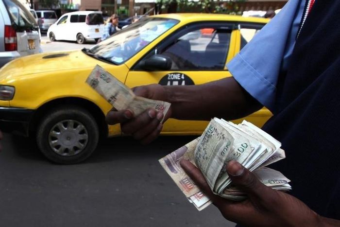 A fuel attendant handles Kenyan shilling notes at a petrol station in the capital Nairobi March 15, 2011   REUTERS/Noor Khamis
