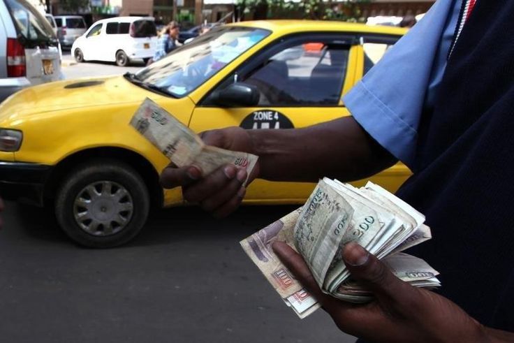 A fuel attendant handles Kenyan shilling notes at a petrol station in the capital Nairobi March 15, 2011   REUTERS/Noor Khamis
