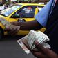 A fuel attendant handles Kenyan shilling notes at a petrol station in the capital Nairobi March 15, 2011   REUTERS/Noor Khamis