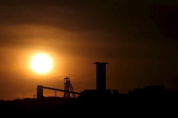 The sun sets behind a shaft outside the mining town of Carletonville, west of Johannesburg, July 7 2015. REUTERS/Siphiwe Sibeko