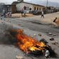 Residents move past a burning barricade on a rock strewn street in Bujumbura's Niyakabiga district on Presidential election day in Burundi, July 21, 2015. REUTERS/Mike Hutchings