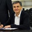 Newly appointed Greek Finance Minister Tsakalotos signs official documents following a swearing-in ceremony at the presidential palace in Athens