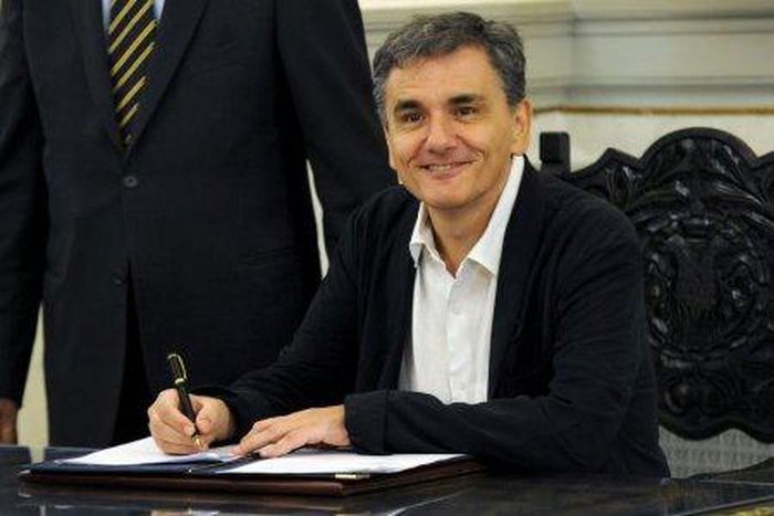 Newly appointed Greek Finance Minister Tsakalotos signs official documents following a swearing-in ceremony at the presidential palace in Athens