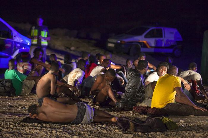 African migrants rest after arriving on a fishing boat at Las Carpinteras beach in the Canary Island of Gran Canaria, Spain, September 1, 2015. REUTERS/Borja Suarez