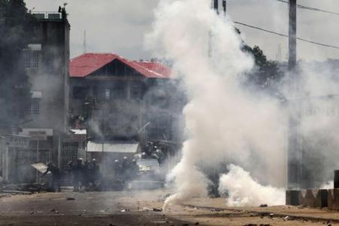 Riot police are seen behind a cloud of tear gas in the Democratic Republic of Congoin a file photo.