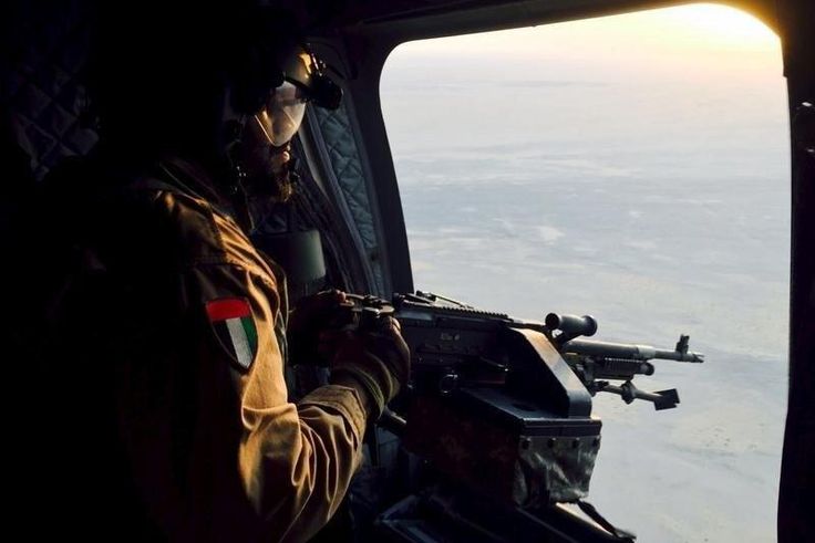 A soldier from the United Arab Emirates armed with a machine gun watches over Yemeni territory while riding a Chinook helicopter en route to a Saudi-led coalition air base in the kingdom September 17, 2015. Armed with high-tech Western weaponry, Gulf A...