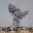 A plume of smoke rises above a building during an air strike in Tikrit March 27, 2015.