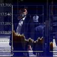 A man using a smartphone is reflected on a graph showing today's movements of Nikkei share average outside a brokerage in Tokyo, Japan, September 29, 2015.    REUTERS/Issei Kato
