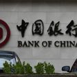 A man is silhouetted in front of a Bank of China's logo at its branch office in Beijing July 14, 2014.   REUTERS/Kim Kyung-Hoon