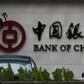 A man is silhouetted in front of a Bank of China's logo at its branch office in Beijing July 14, 2014.   REUTERS/Kim Kyung-Hoon