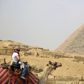 A British tourist rides a camel in front of the Giza pyramids on the outskirts of Cairo, Egypt, November 8, 2015. REUTERS/Amr Abdallah Dalsh