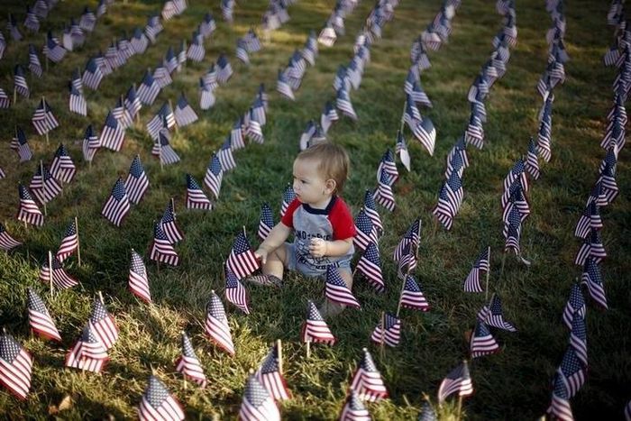 A baby sits in a field of flags to honor victims of the September 11, 2001 attacks, in Santa Clarita, California, September 11, 2015.   REUTERS/Lucy Nicholson