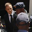 South African Olympic and Paralympic sprinter Oscar Pistorius (C) is escorted to a police van after his sentencing at the North Gauteng High Court in Pretoria October 21, 2014. REUTERS/Siphiwe Sibeko/Files
