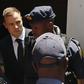 South African Olympic and Paralympic sprinter Oscar Pistorius (C) is escorted to a police van after his sentencing at the North Gauteng High Court in Pretoria October 21, 2014. REUTERS/Siphiwe Sibeko/Files