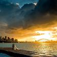Photographer Sam Yeldham captured the clouds parting for a picture perfect minute behind the happy newlyweds (pictured)