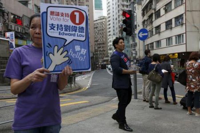 Edward Lau (R), 29, a businessman who participated in Occupy Central protests in 2014 and is running for the upcoming district elections, campaigns with a supporter in Hong Kong, China November 11, 2015.