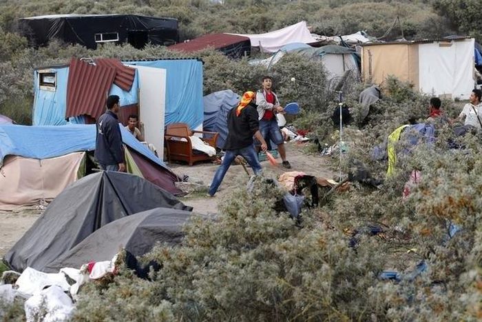 Migrants play paddle ball near tents in the makeshift camp called "The New Jungle" in Calais, France, August 19, 2015. REUTERS/Regis Duvignau