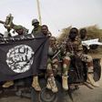 Nigerian soldiers hold up a Boko Haram flag that they had seized in the recently retaken town of Damasak, Nigeria, March 18, 2015.