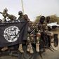 Nigerian soldiers hold up a Boko Haram flag that they had seized in the recently retaken town of Damasak, Nigeria, March 18, 2015.
