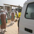 Healthcare workers prepare to disinfect an ambulance transporting a newly admitted Ebola patient at the entrance to the Save the Children Kerry Town Ebola treatment centre outside Freetown, Sierra Leone, December 22, 2014. REUTERS/Baz Ratner