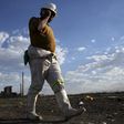 A mine worker speaks on his mobile phone as he returns from the Lonmin mine at the end of his shift, outside Rustenburg, northwest of Johannesburg, South Africa November 10, 2015. REUTERS/Siphiwe Sibeko