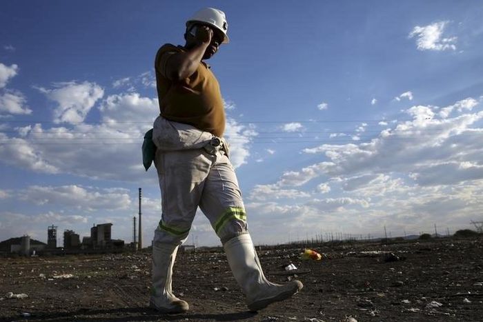 A mine worker speaks on his mobile phone as he returns from the Lonmin mine at the end of his shift, outside Rustenburg, northwest of Johannesburg, South Africa November 10, 2015. REUTERS/Siphiwe Sibeko