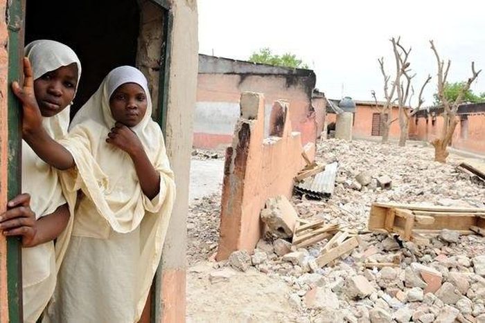 Female students stand in a destroyed school in Northern Nigeria