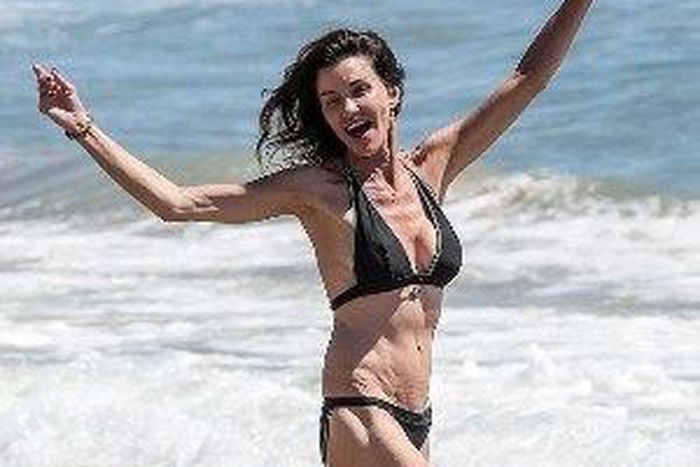 Janice Dickinson rocking a black halter neck bikini, while frolicking at a Malibu Beach