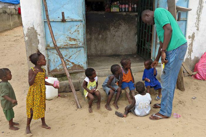Mamadou Ka greets children near his family home after being repatriated last month from Gabon, in Dakar, Senegal, September 2, 2015. REUTERS/Makini Brice