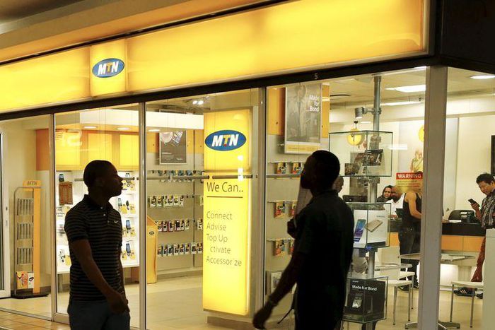 Bystanders walk past an outlet of South Africa's MTN Group in downtown Cape Town, November 10, 2015.   REUTERS/Mike Hutchings