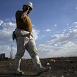 A mine worker speaks on his mobile phone as he returns from the Lonmin mine at the end of his shift, outside Rustenburg, northwest of Johannesburg, South Africa November 10, 2015. REUTERS/Siphiwe Sibeko