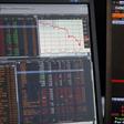 A sales manager sits near a screen with a graphic that shows a decline in value of French CAC 40 stocks at Allianz Global Investors in Paris, France, August 24, 2015. REUTERS/Regis Duvignau