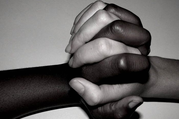Interracial couple entwine hands
