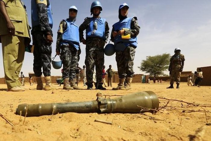 Peace keepers from the United Nations Hybrid Operation in Darfur (UNAMID) look at an RPG-7 projectile that was found at the Al-Abassi camp for internally displaced persons, after an attack by rebels, in Mellit town, North Darfur March 25, 2014. REUTERS...