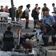 A migrant hands a baby to a Hellenic Coast Guard officer following a rescue operation, at the port on the Greek island of Kos, August 17, 2015. REUTERS/Alkis Konstantinidis