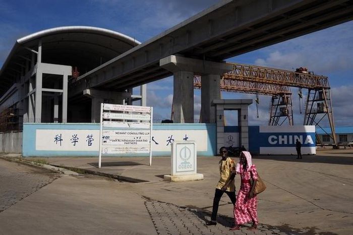 People walk by the National Arts Theatre stop of the light rail system under construction in Lagos, Nigeria, May 30, 2014. REUTERS/Joe Penney