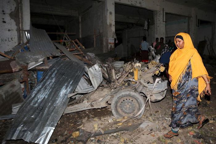 A Somali woman walks past the scene of a suicide car bomb attack near Juba hotel in capital Mogadishu August 22, 2015.  REUTERS/Feisal Omar