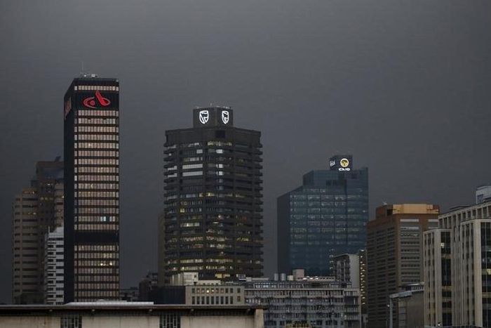 The logos of South Africa's three biggest banks, ABSA, Standard Bank and First National Bank (L-R), adorn buildings as winter storms hit Cape Town, July 8, 2015.  REUTERS/Mike Hutchings