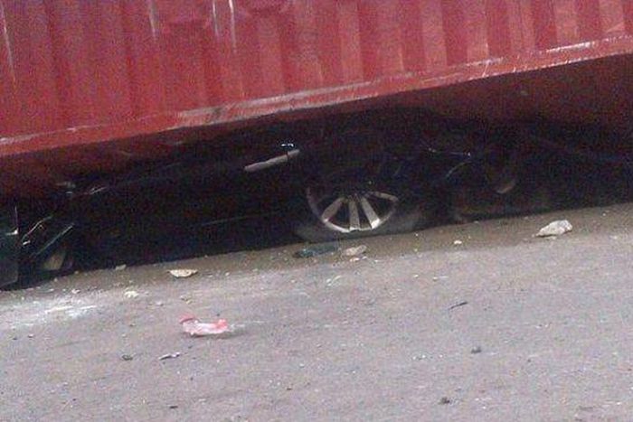 The crushed car underneath the trailer (Illustration)