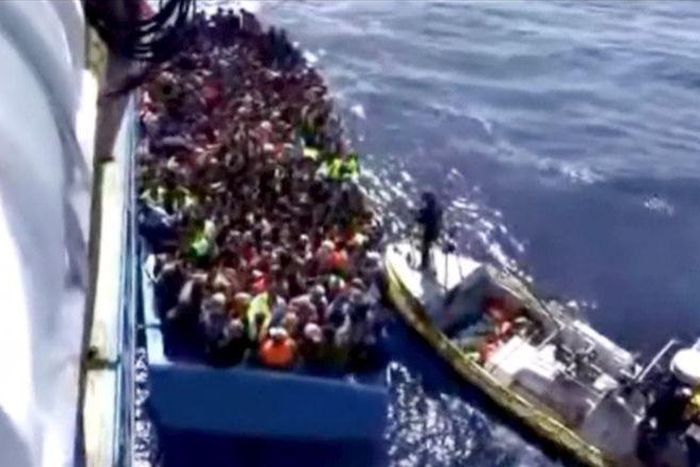 A boat full of migrants is seen next to Swedish ship Poseidon during a rescue operation in the sea off the coast of Libya in this still image taken from an August 26, 2015 video. REUTERS/Swedish Coast Guard Handout via Reuters TV